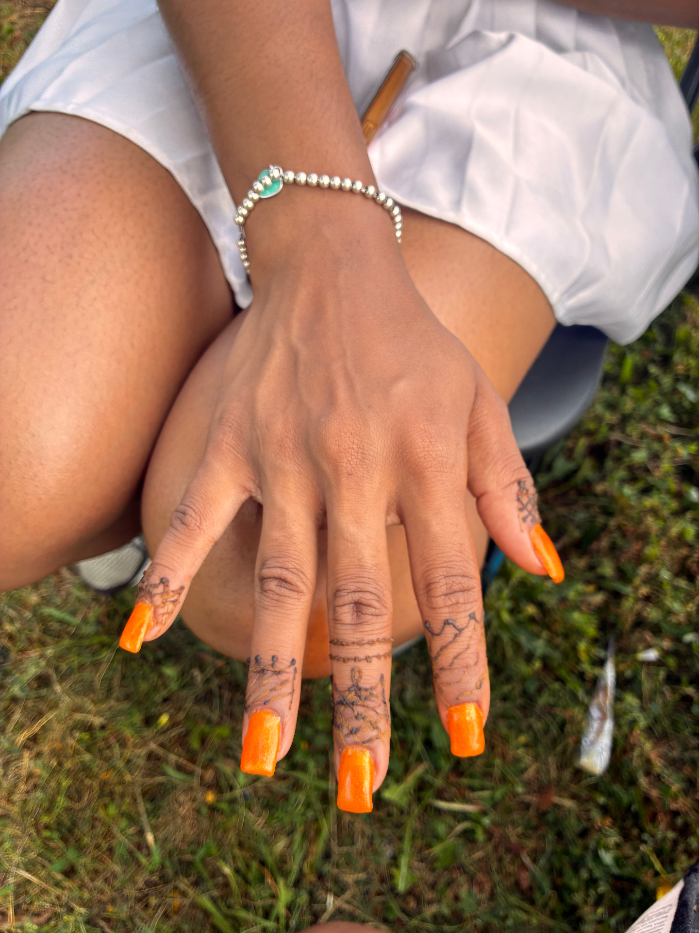 Intricate freeform henna across fingers and knuckles