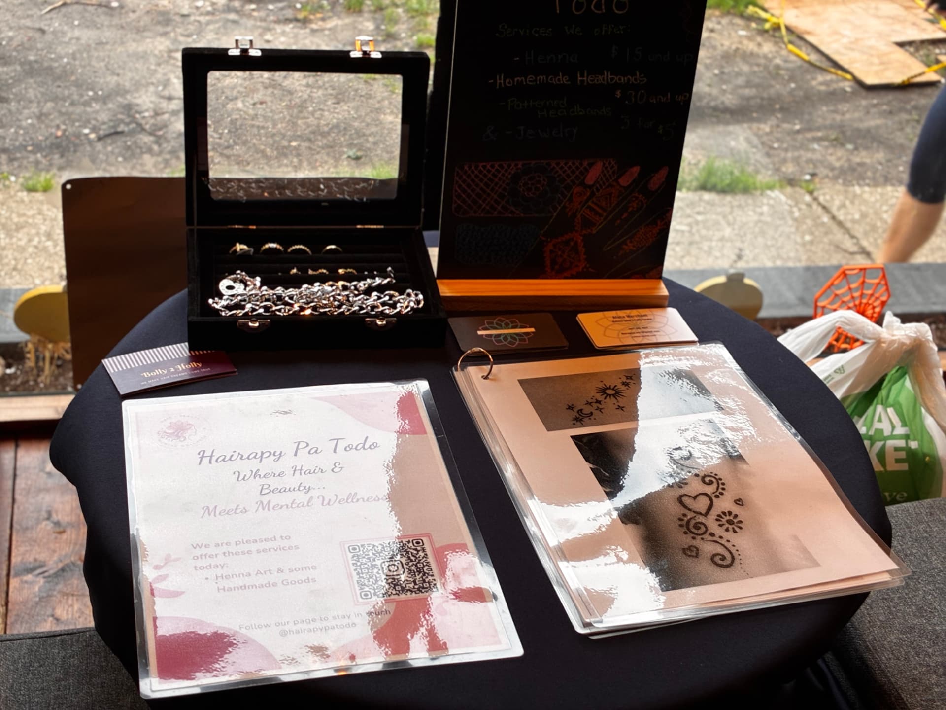 Pop-up table with jewelry, design portfolio, and brand signage