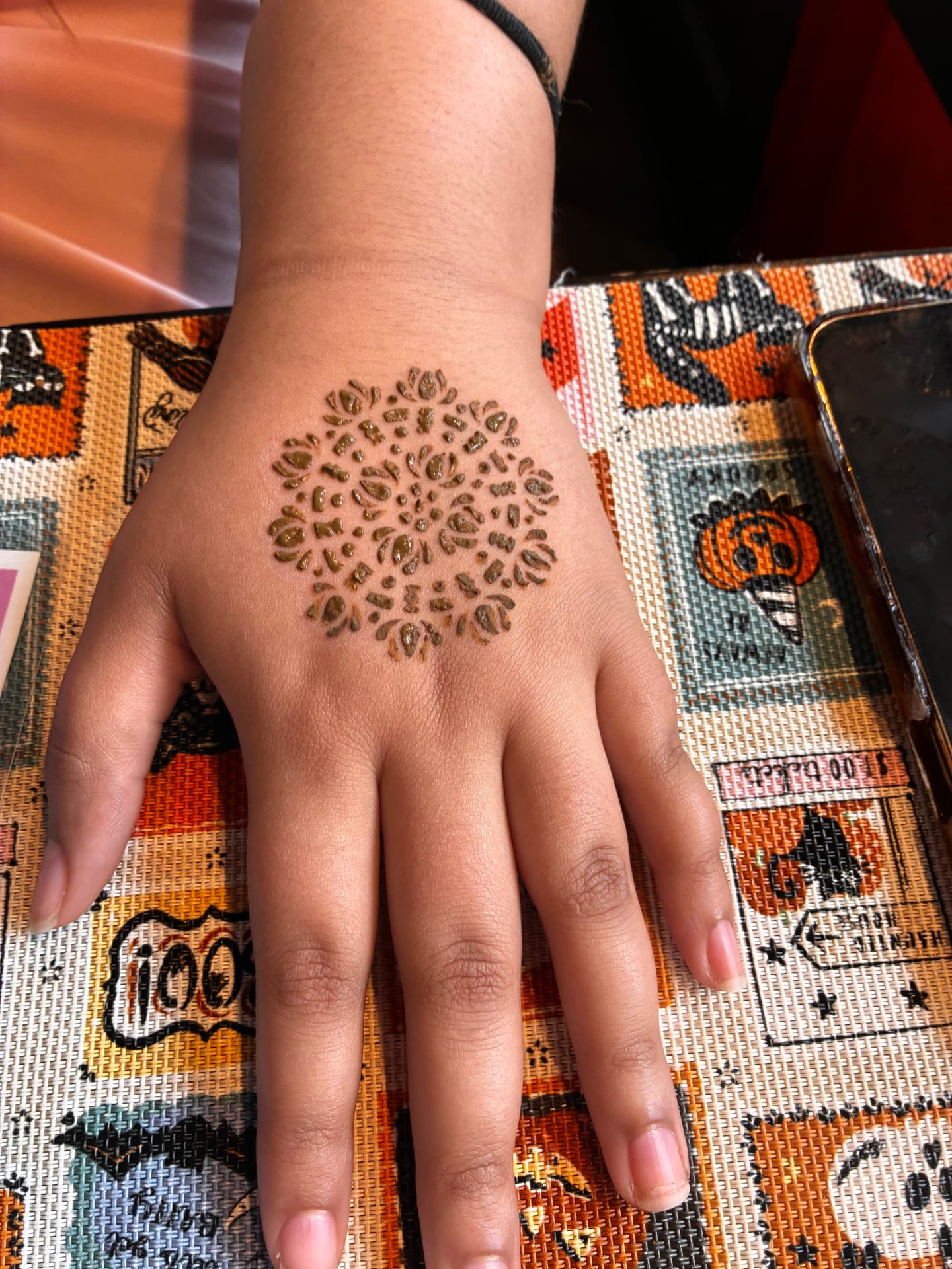 Freeform henna mandala on the back of a hand