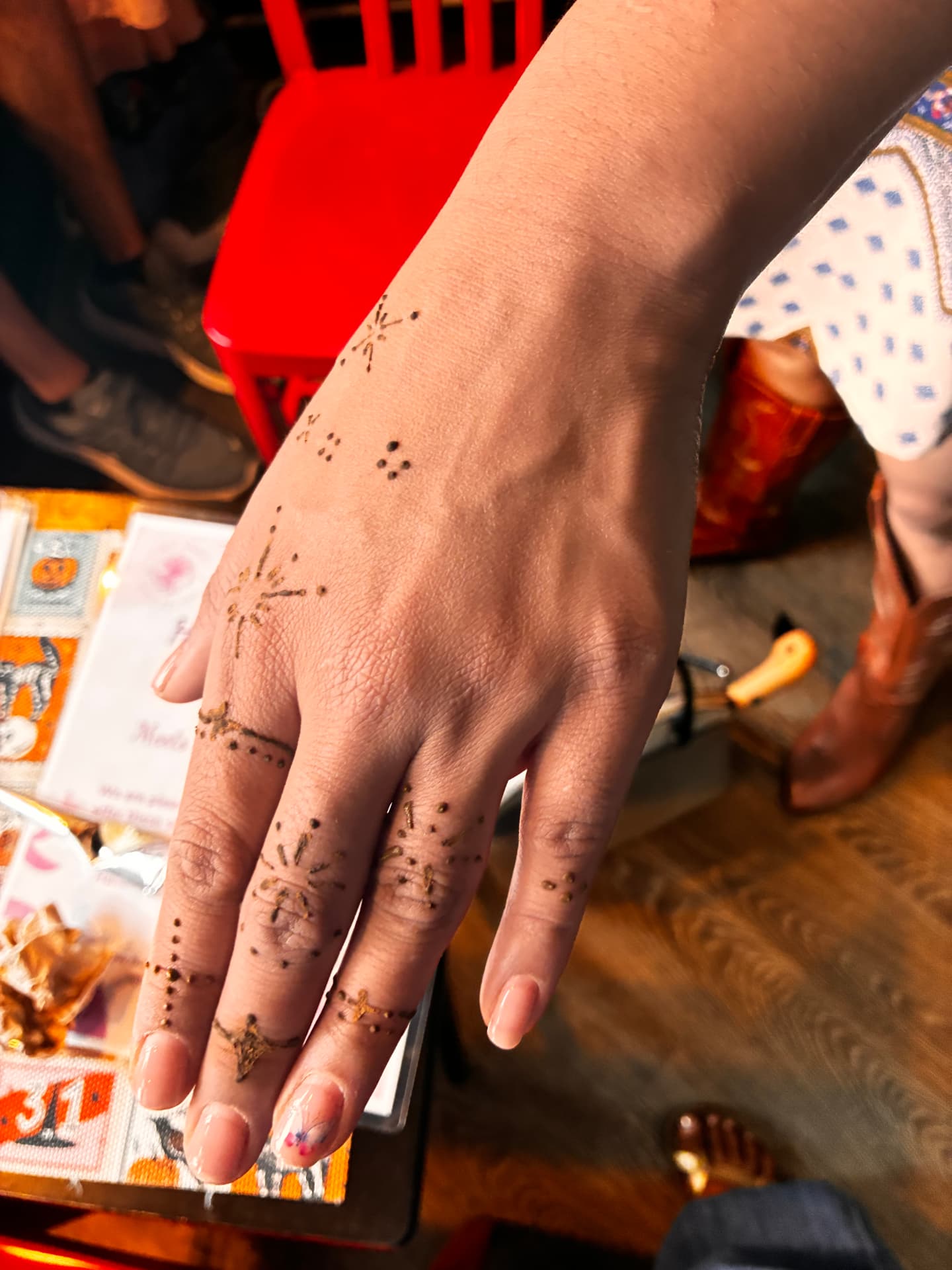 Delicate dotted henna stars across fingers and hand