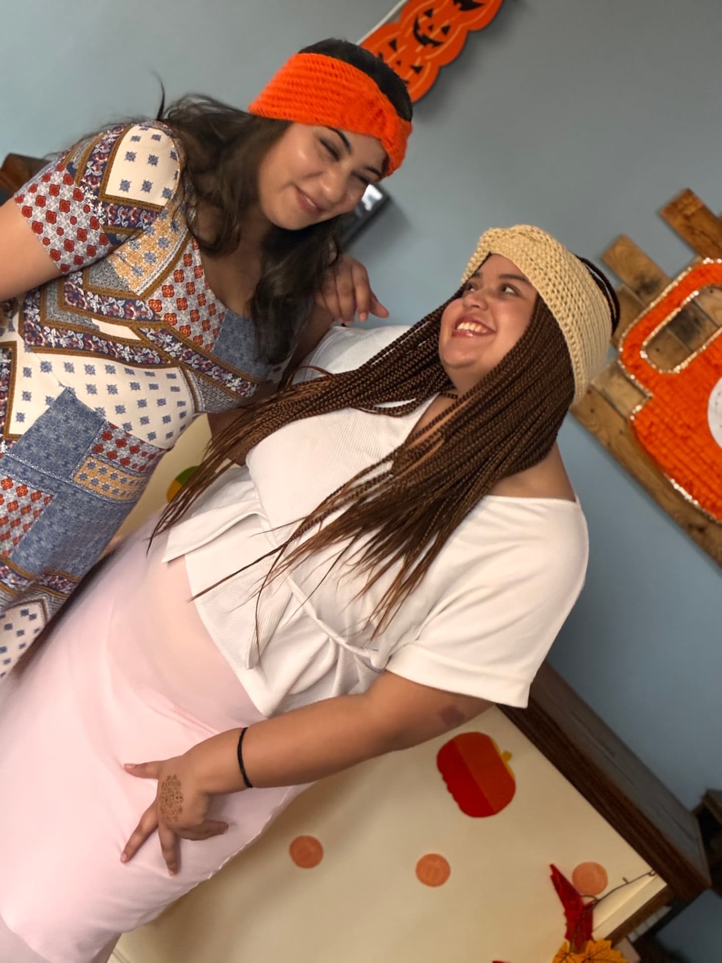 Two friends laughing while wearing crocheted headbands